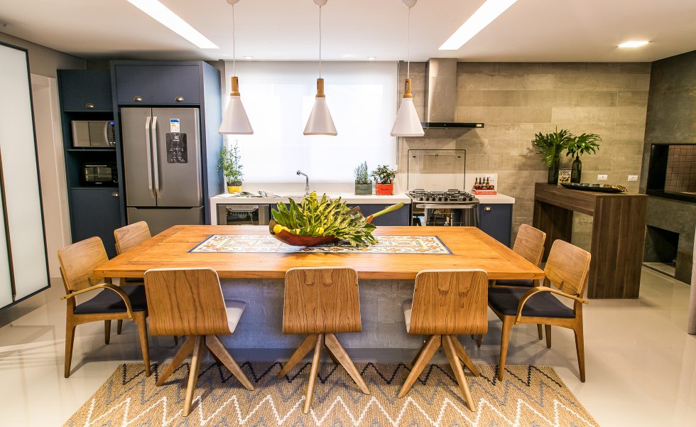 Na lateral da cozinha, a bancada móvel da churrasqueira foi solicitada especialmente pelo marido para curtir com os amigos. A cristaleira com portas de vidro branco extraclear para a louçaria