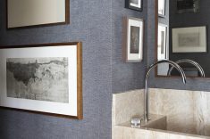 No lavabo a arandela vintage em vidro (refletida) é outras das peças garimpadas. 