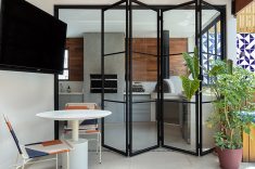 A porta camarão de vidro amplia a conexão entre a área gourmet e o terraço.