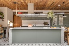 A cozinha foi dimensionada para acompanhar a circulação da família e o hábito dos moradores de cozinhar e receber. A ilha central organiza o uso cotidiano do espaço e concentra parte importante da dinâmica social da residência.