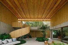 A escada em espiral, revestida em biriba, conecta os dois pavimentos e se transforma em um dos principais elementos escultóricos da residência.