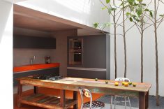 A cozinha ocupa um dos extremos da casa e se conecta diretamente ao jardim interno.